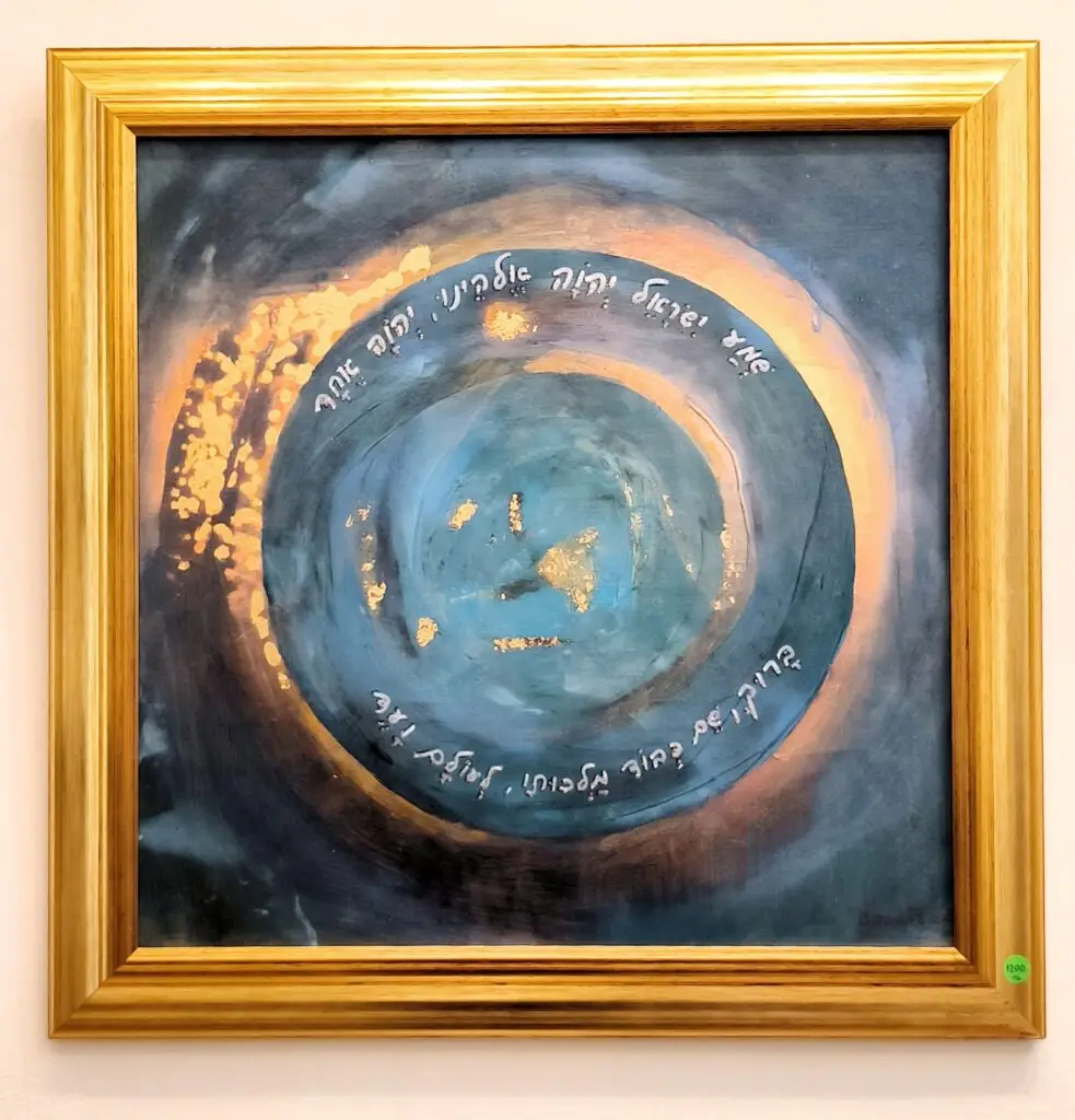 "שמע ישראל" היא יצירה בטכניקה מעורבת: הדפס ג'יקלה, אקריליק ועלי זהב.